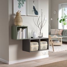 a living room filled with furniture next to a wall mounted book shelf on the side of a wall