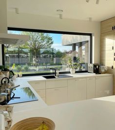 a kitchen with a large window and white counter tops