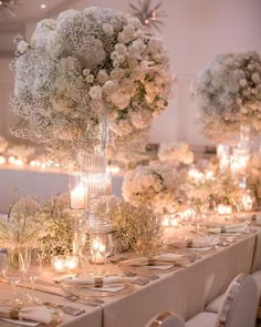 the table is set with white flowers and candles for an elegant dinnereonal look