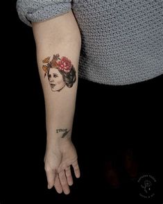 a woman with a flower in her hair is holding the hand of another person's arm