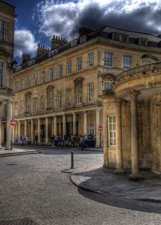 a group of people standing in front of a building on a cobblestone street