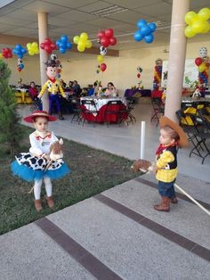 two children dressed up as toy story book characters at a birthday party with balloons and streamers