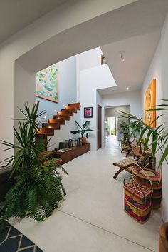 the inside of a house with plants and potted plants on either side of the stairs