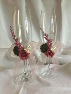 two wine glasses decorated with flowers and ribbons