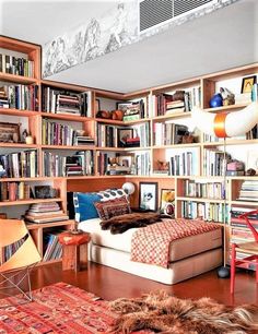 a bedroom with lots of bookshelves and a bed in the middle is shown