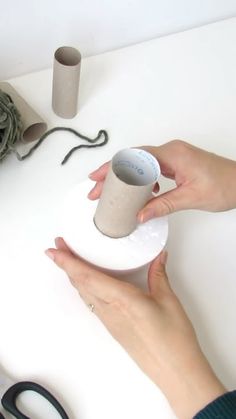 a woman is using a sewing machine to sew something on a white table top