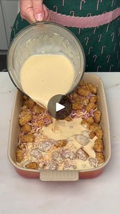 someone pouring batter into a casserole dish with meatballs and cheese in it