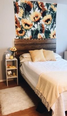 a bed sitting in a bedroom next to a wall with sunflowers on it