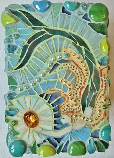 a decorative tile with an image of a sea horse on it's side and pearls around the edges