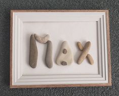 three rocks are arranged in the shape of x and y on a white framed frame