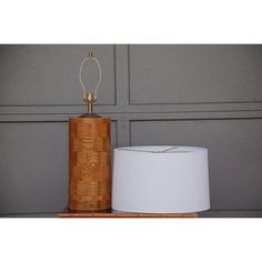 a wooden table lamp next to a white shade