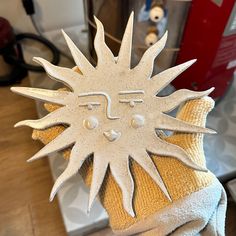 a close up of a person's hand wearing a glove with a sun design on it