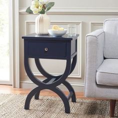 a blue end table with a white bowl on it and a gray chair in the background