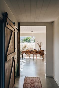 an open door leading to a dining room with a table and chairs in the background