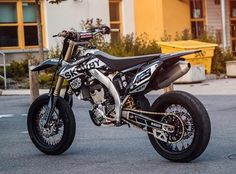 a black and white dirt bike parked on the street