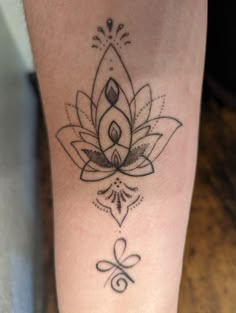 a tattoo on the leg of a woman with a flower and leaf design in black ink