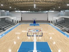 an indoor basketball court with wooden floors and blue rims is shown in this image