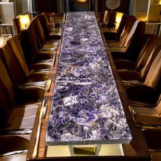 a long table with purple marble on it in a room filled with brown leather chairs