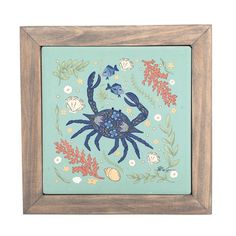 a blue crab is surrounded by seaweed and corals in a wooden frame on a white background