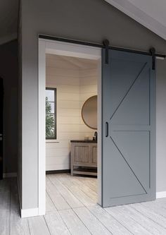 an open door leading to a bedroom with white walls and wood flooring on the side