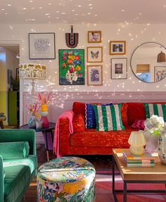 a living room filled with colorful furniture and pictures on the wall above it's fireplace