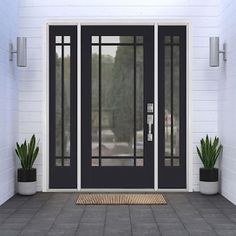 a black front door with two potted plants on the side and an entrance mat