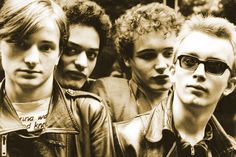 a group of young men standing next to each other in front of a crowd with sunglasses on