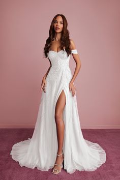 a woman in a white wedding dress posing for the camera with her leg slit open