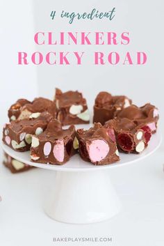 a white cake plate topped with pink and white chocolate rocky road bites on top of it