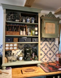 an old fashioned kitchen cabinet with many items on it