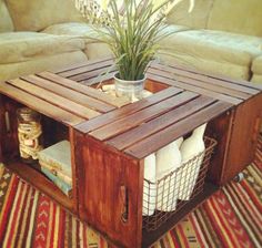 a coffee table made out of wooden crates with baskets on top and a plant in the middle