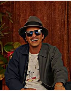 a man wearing sunglasses and a hat smiling