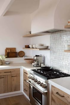 a stove top oven sitting inside of a kitchen next to wooden cabinets and counter tops