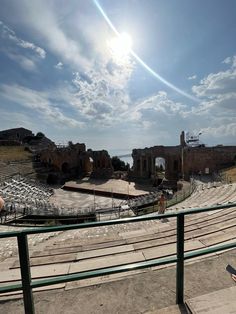 the sun shines brightly over an ancient theater