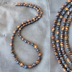 Introducing the "Eye of the Tiger" men's beaded necklace, a striking piece that combines the rugged elegance of natural stones with the bold style you seek. This necklace is meticulously handcrafted, featuring a powerful trio of Tiger Eye, Lava, and Hematite stones, each bead measuring a perfect 6mm. The Stones: Tiger Eye: Known for its captivating golden to reddish-brown hues, Tiger Eye is a stone of protection and grounding. It brings sharpness to one's inner vision and aids in manifesting wil Black Ninja, Tiger Eye Necklace, Mens Beaded Necklaces, Trending Necklaces, Brown Necklace, Beaded Jewels, Hematite Stone, Bold Style, Men Jewelry