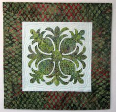 a green and red quilted wall hanging