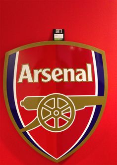 a red and blue shield with the word arsenal on it's side