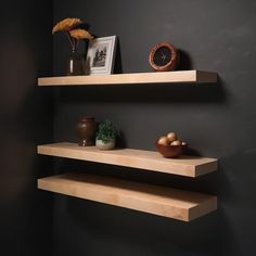 two wooden shelves on the wall with plants and vases next to them in front of a clock