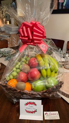 a basket filled with lots of fruit sitting on top of a table next to a card