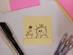 a notepad with a drawing of a person holding a flower next to pens and markers