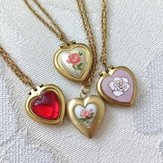 Lovely tiny and UNUSED 70S VINTAGE heart lockets available in different finished (explained below) on dainty gold plated chain measuring 16" (40cm) + 2" =  40cm +5 cm of extender chain.      OPTIONS: 1. Tiny 50s vintage Japanese porcelain heart. 2. Porcelain heart with rust orange rose. 3.  Pink enamelled copper with rose, from the 60s.  4. Red domed heart is first quality plastic.  # 2, 3 &: 4 will hold one picture each side and measure: 14mm x 16mm. ( 0,55" x 0.63"). #1 measures 15x16mm and ha