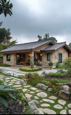 a house with stone walkways in front of it and landscaping around the yard area