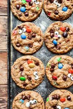 chocolate chip cookies decorated with m & m eyes and candy on a baking sheet, ready to be eaten