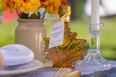 a bottle of maple syrup sitting on top of a table next to plates and glasses