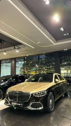 two luxury cars are parked in a showroom