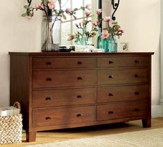 a dresser with flowers and vases on top