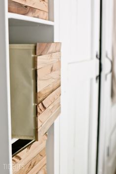 a white cabinet with wooden drawers in it