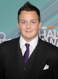 a young man in a suit and tie posing for the camera at an awards event