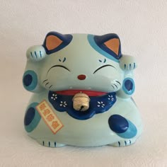 a ceramic cat figurine with a tag on it's collar and nose