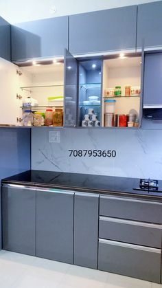 an empty kitchen with stainless steel cabinets and counter tops is seen in this image, the cabinet doors are open